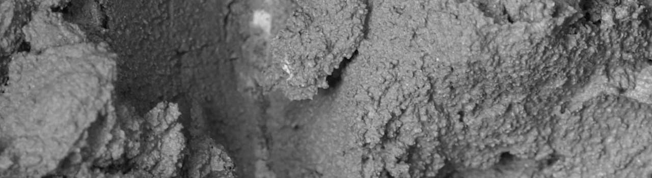 Detail of liquid concrete formed by mixed cement, water and sand - (16:9 black and white)
